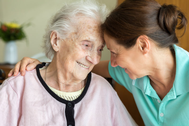Senior Woman and Home Caregiver smiling together